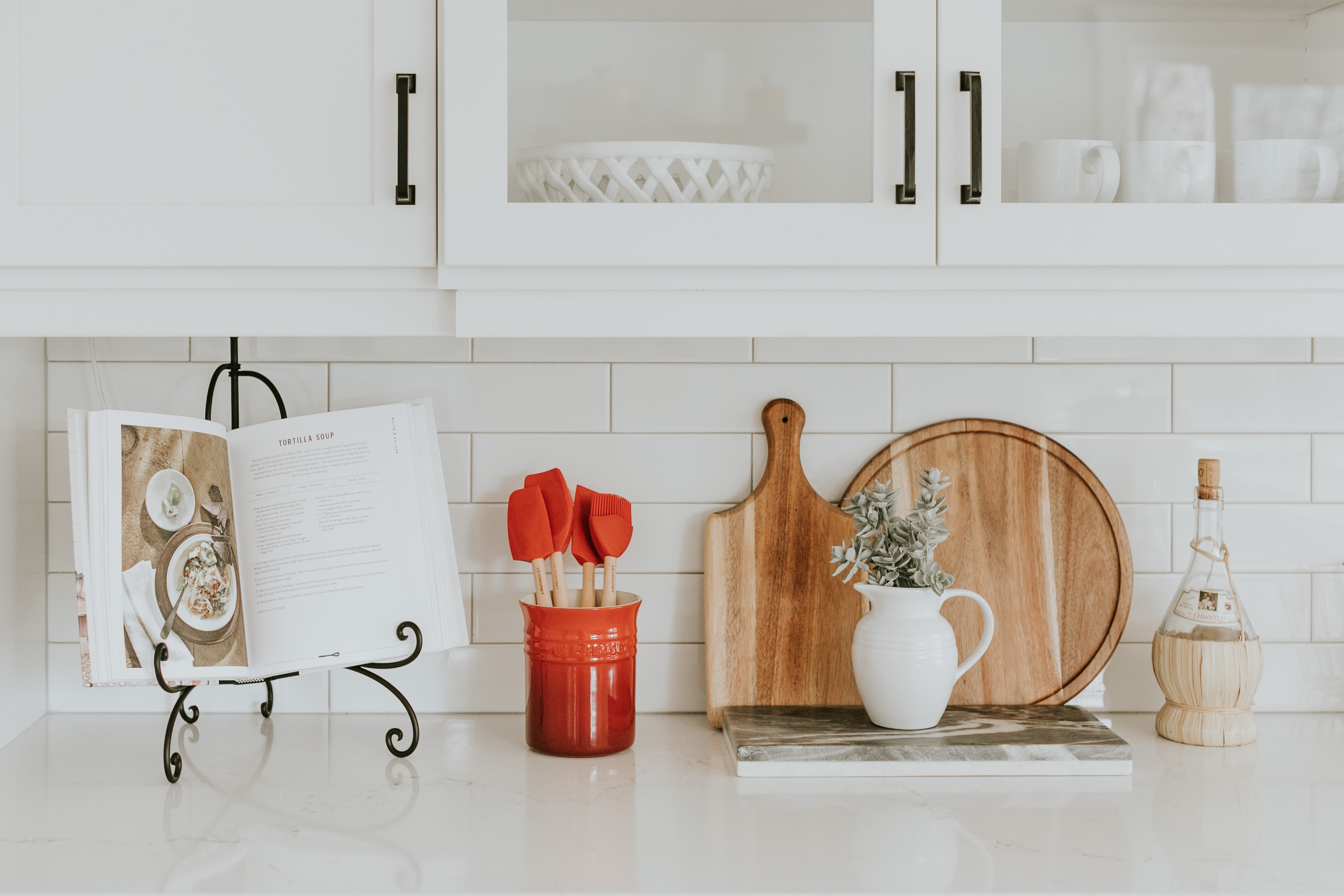 Elegant kitchen with white counter, plants, and wood cutting boards