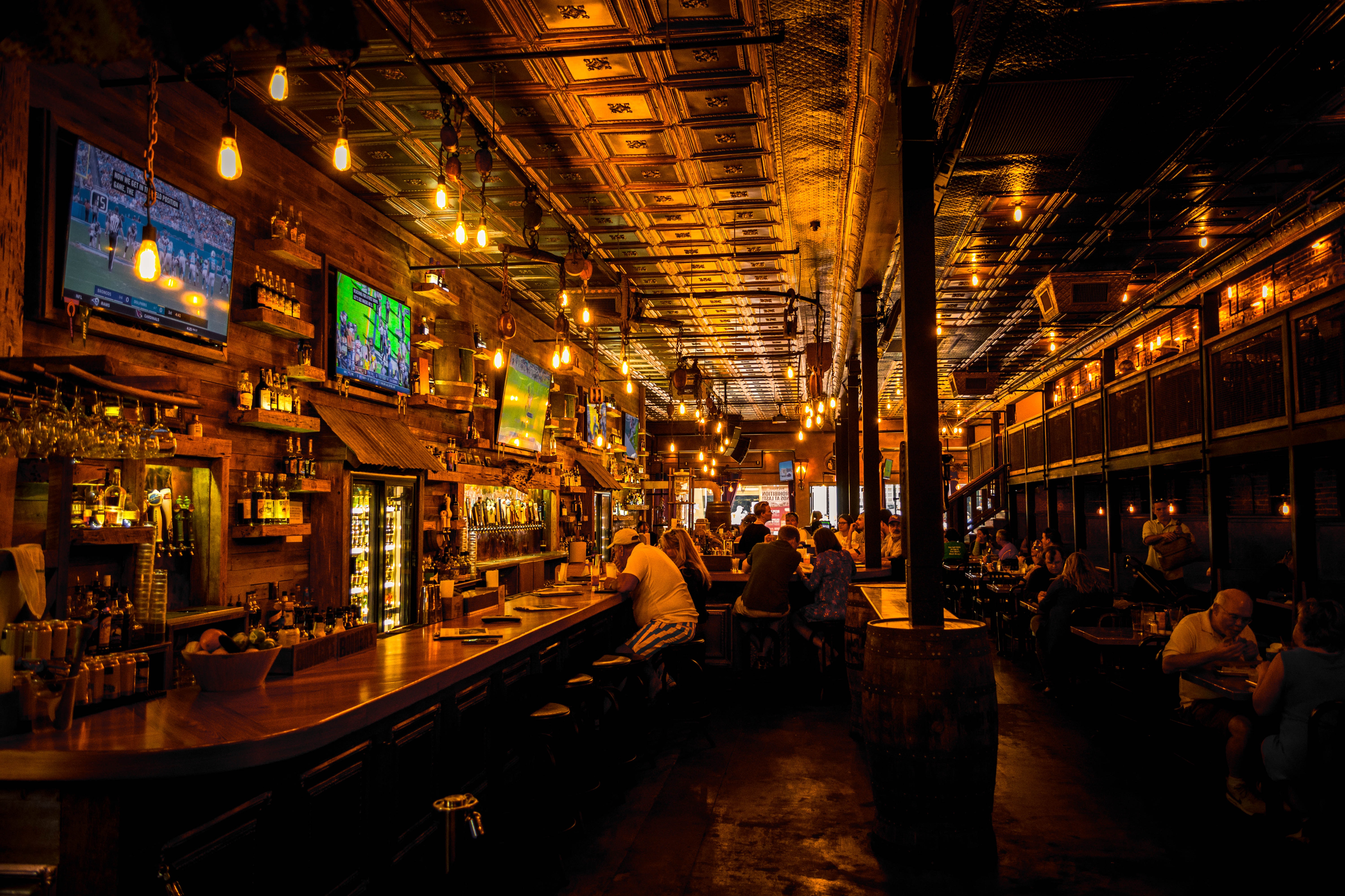 A sports pub with crowds and large TVs playing football games