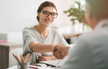 manager shaking the hand of a newly-hired professional