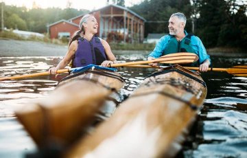 retired couple enjoys kayaking on the lake thanks to their IRA investments