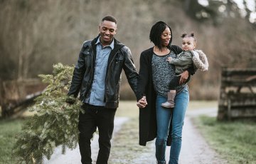 couple walking in park with their child